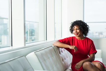 Woman with a Master of Legal Studies sitting on a white couch